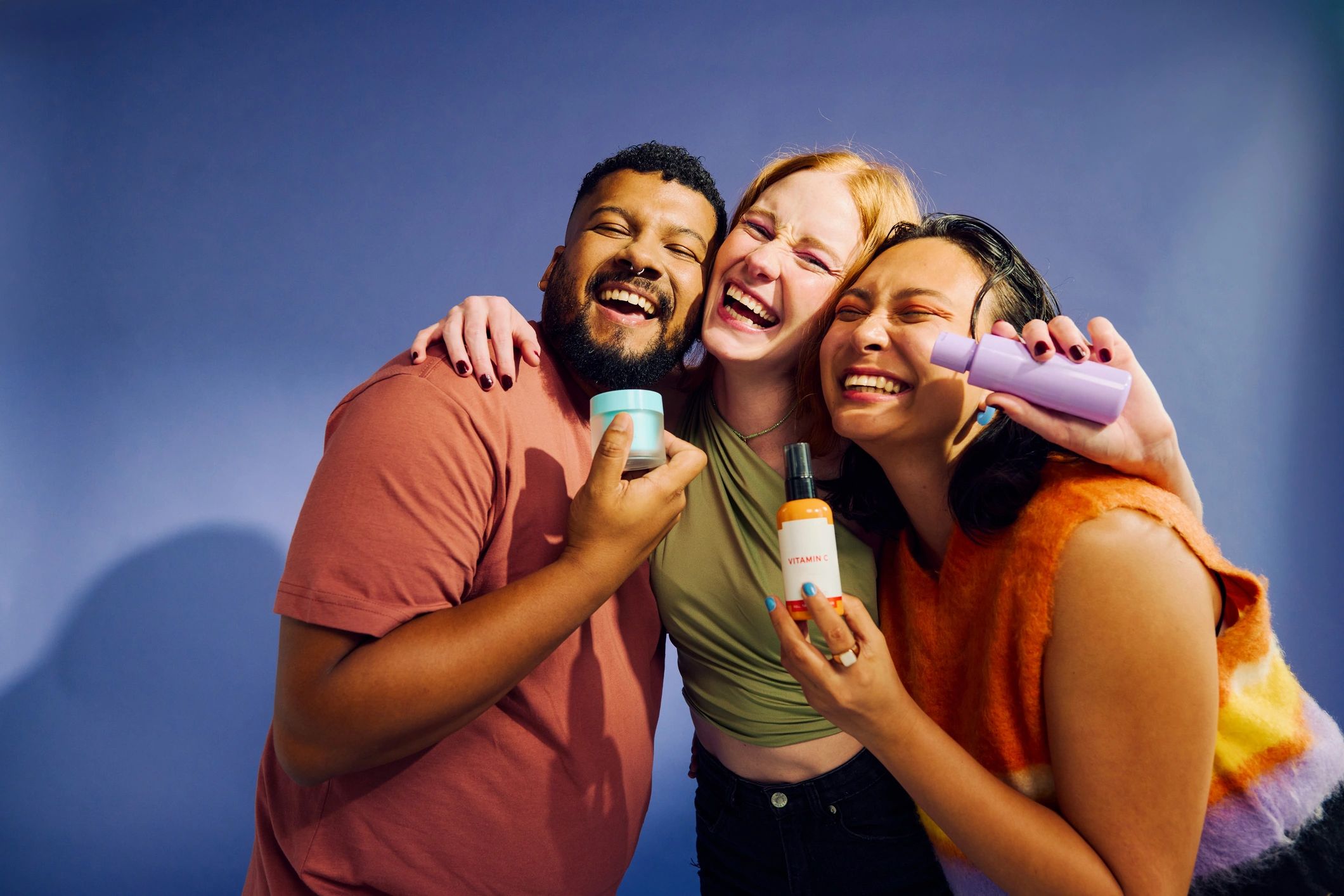 Group of joyful diverse people with beauty products